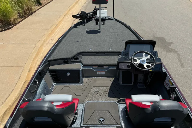 Slide: The Image of 2027 Nitro Z21 XL Pro boat interior with steering wheel and seating, parked on a street. - 14