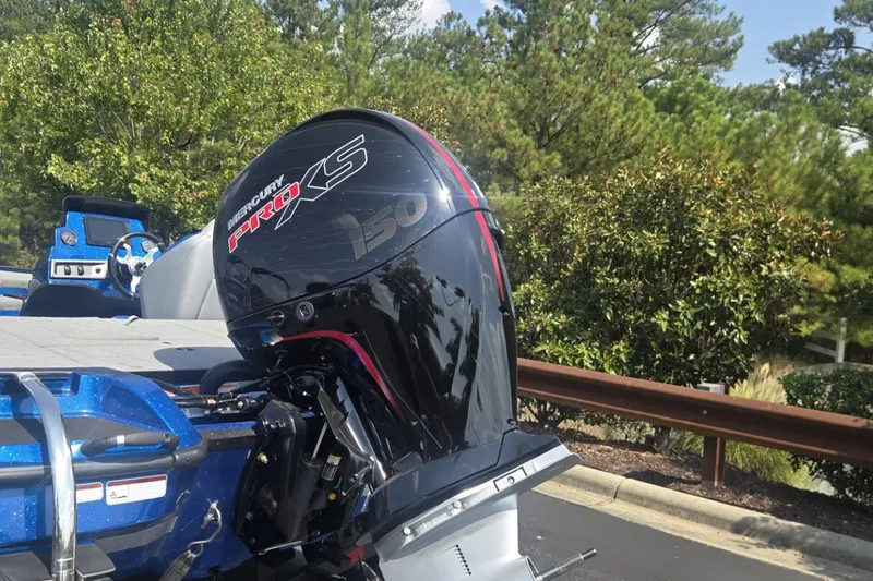 Slide: The Image of Outboard motor on a 2027 Nitro Z18 XL Pro boat, parked near trees. - 2