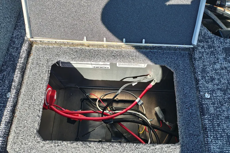 Slide: The Image of Open battery compartment in 2025 Tracker Targa V-18 WT boat, showing wiring and connections. - 20