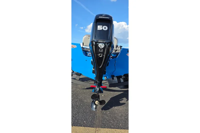 Slide: The Image of 2027 Tracker Pro Guide V-16 SC with Mercury 50 outboard motor, parked on pavement. - 46