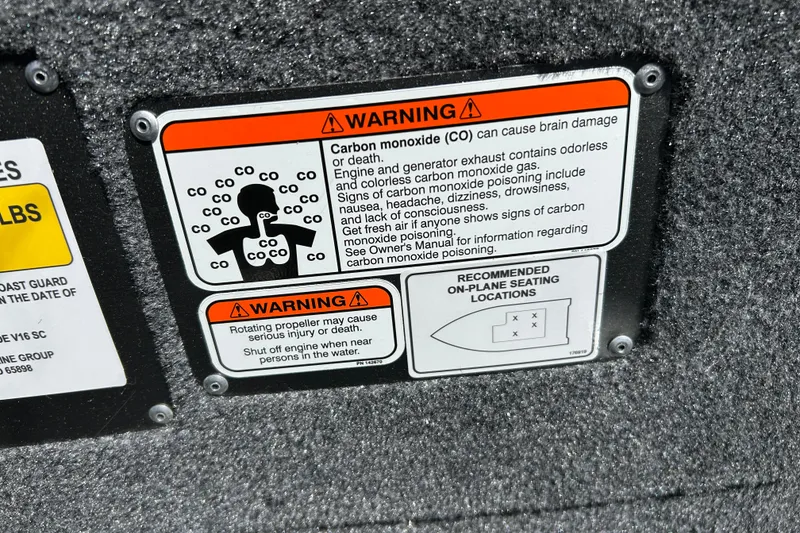 Slide: The Image of Warning labels on a 2027 Tracker Super Guide V-16 SC boat, highlighting carbon monoxide and propeller hazards. - 13