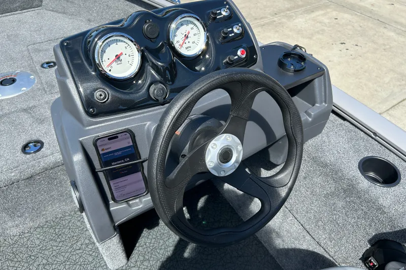 Slide: The Image of Steering console of 2027 Tracker Super Guide V-16 SC boat with gauges and smartphone holder. - 41