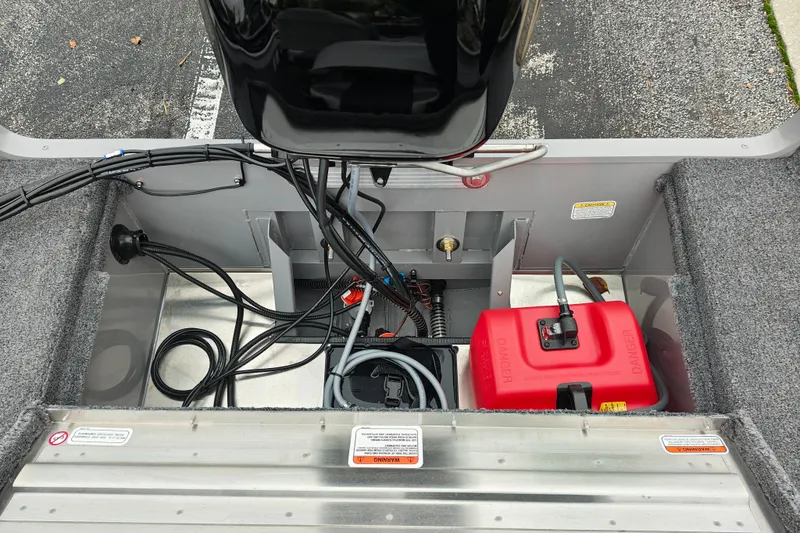 Slide: The Image of 2027 Tracker Super Guide V-16 SC boat interior with wiring and red fuel tank. - 27