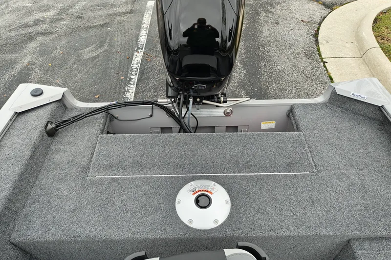 Slide: The Image of 2027 Tracker Super Guide V-16 SC boat interior with motor and carpeted deck. - 26