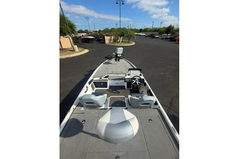 Slide: The Image of 2027 Nitro Z21 XL Pro boat interior with steering console and seating in a parking lot. - 5