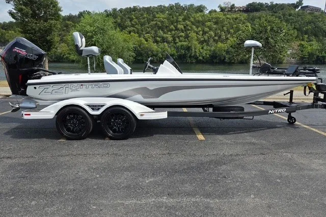Slide: The Image of 2027 Nitro Z21 XL Pro boat on trailer, parked near a scenic riverbank. - 0