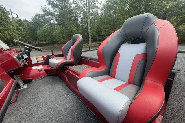Slide: The Image of Red and gray seats in a 2027 Nitro Z19 XL Pro boat, surrounded by trees. - 8