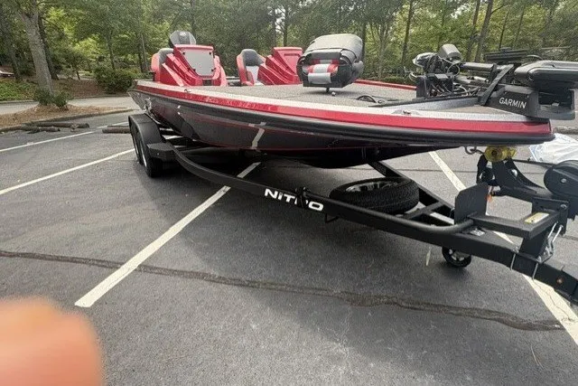 Slide: The Image of 2027 Nitro Z19 XL Pro bass boat in parking lot, featuring red and black design. - 1