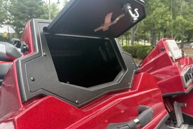Slide: The Image of Red 2027 Nitro Z19 XL Pro boat with open storage compartment, surrounded by trees. - 7