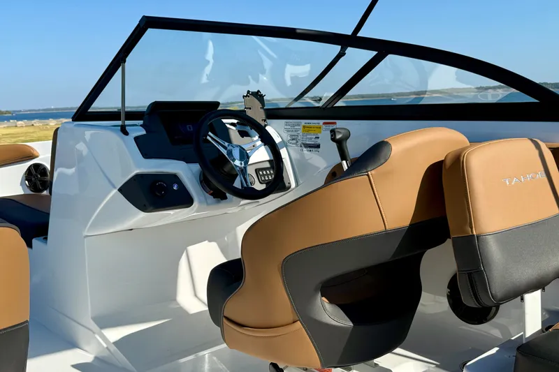 Slide: The Image of Interior view of 2027 Tahoe 210 S boat with modern steering and tan seats. - 16
