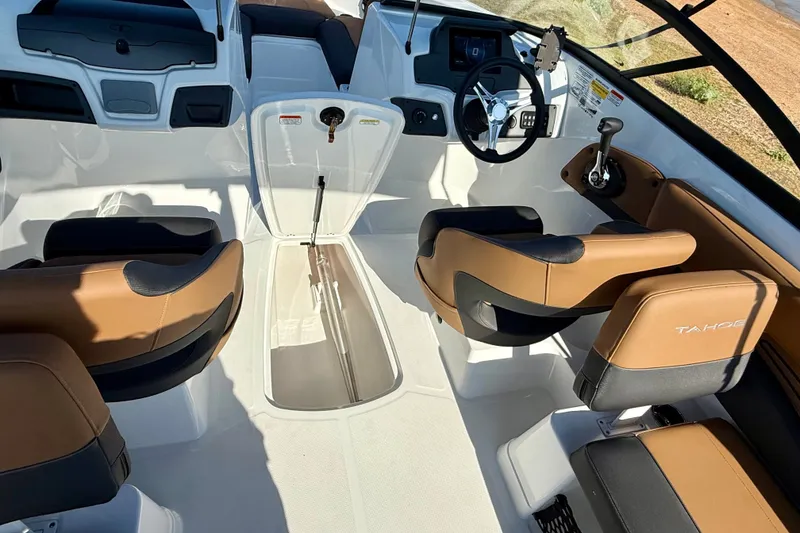 Slide: The Image of 2027 Tahoe 210 S boat interior with tan and black seating, steering wheel, and control panel. - 18