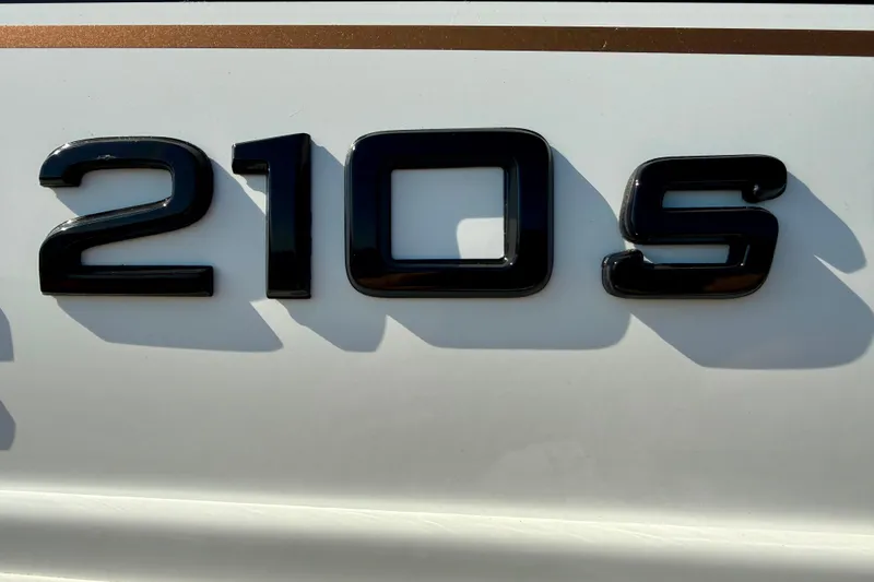 Slide: The Image of Close-up of Tahoe 210 S 2027 model emblem on white surface. - 27