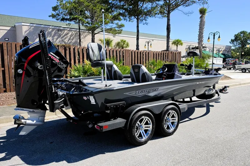 Slide: The Image of 2026 Ranger ALPHA 208 boat on trailer, parked outdoors, showcasing sleek design and powerful engine. - 4