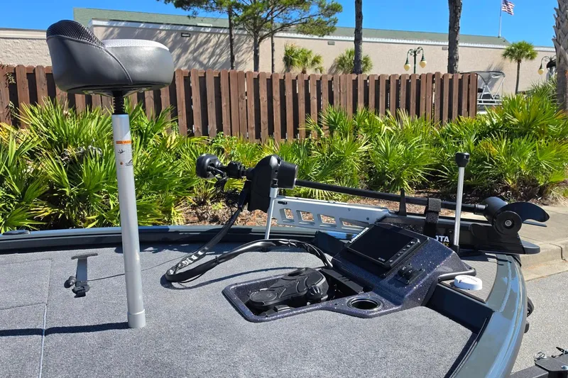 Slide: The Image of 2026 Ranger ALPHA 208 boat deck with seat, control panel, and lush greenery background. - 19