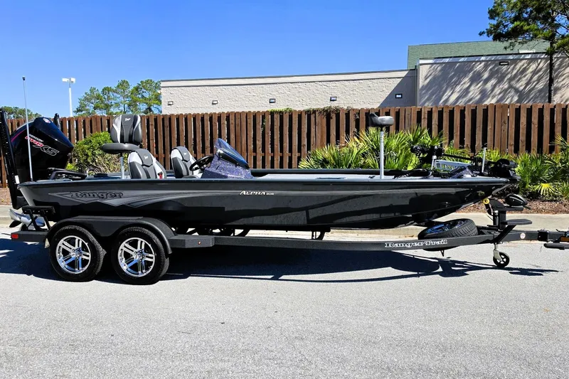 Slide: The Image of 2026 Ranger ALPHA 208 boat on trailer, parked outdoors, side view. - 1