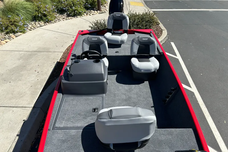 Slide: The Image of 2027 Tracker Bass Tracker Classic XL boat with gray seating and red trim, parked on pavement. - 15