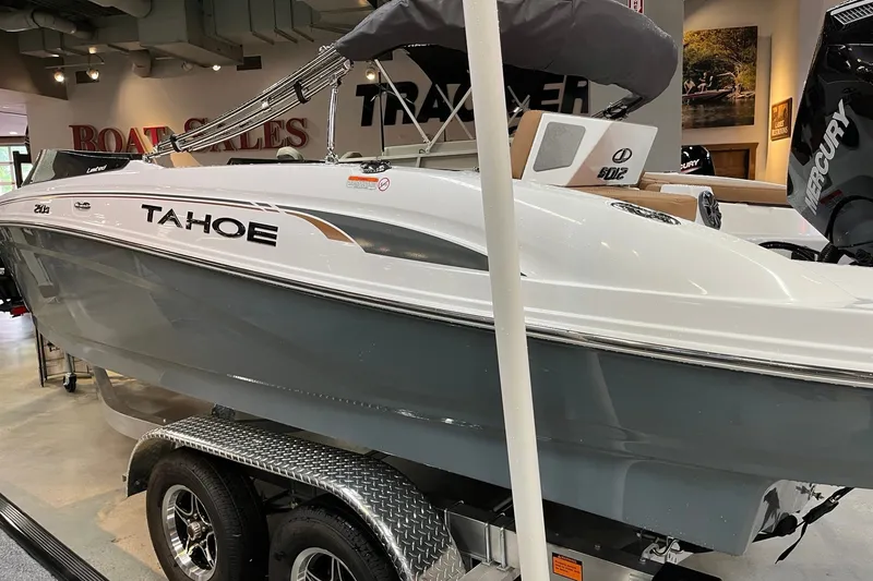 Slide: The Image of 2027 Tahoe 210 S boat displayed in showroom with Mercury engine. - 2