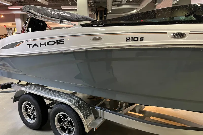 Slide: The Image of 2027 Tahoe 210 S boat on trailer in showroom setting. - 5