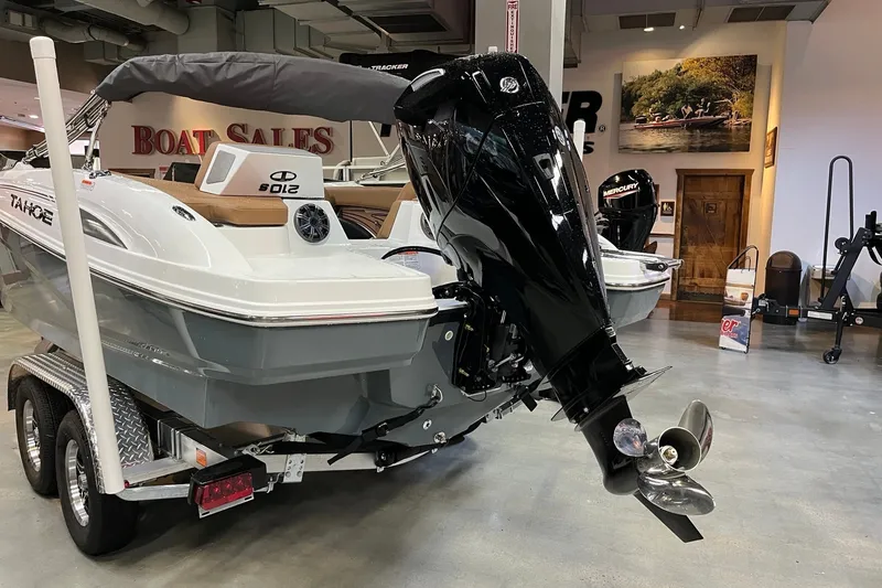Slide: The Image of 2027 Tahoe 210 S boat on trailer in showroom, featuring powerful outboard motor. - 3