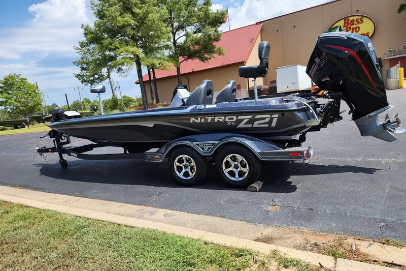 Slide: The Image of 2027 Nitro Z21 XL Pro boat parked outside Bass Pro Shops on a sunny day. - 1