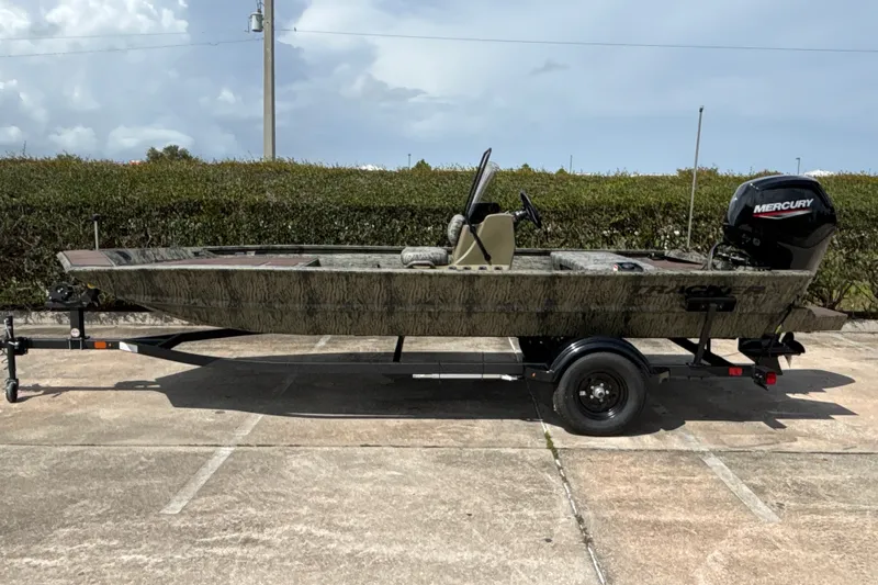 The Image of 2027 Tracker Grizzly 1860 CC boat on trailer, outdoors, with Mercury engine. - 0