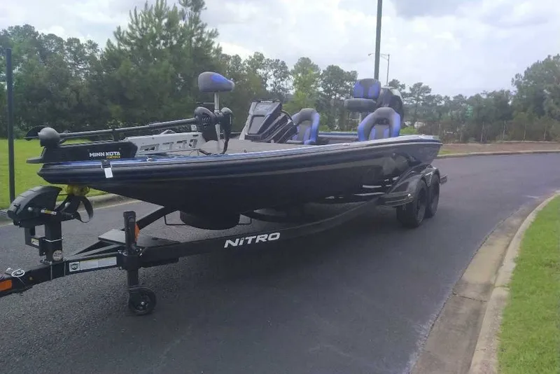 Slide: The Image of 2027 Nitro Z21 XL boat on trailer, parked on a road with lush greenery. - 3