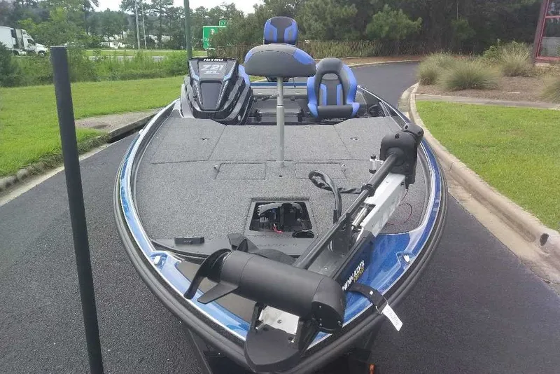 Slide: The Image of 2027 Nitro Z21 XL bass boat with trolling motor on a paved road. - 1