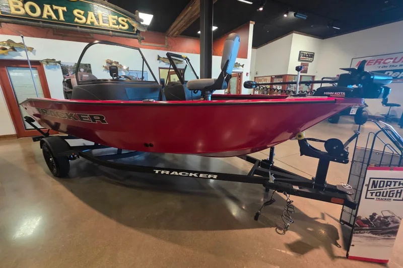 The Image of 2027 Tracker Pro Guide V-16 WT boat displayed in showroom, vibrant red color, on trailer. - 0