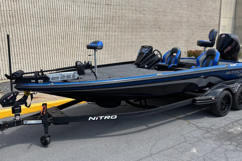 Slide: The Image of 2027 Nitro Z21 XL bass boat with blue accents on a trailer. - 2