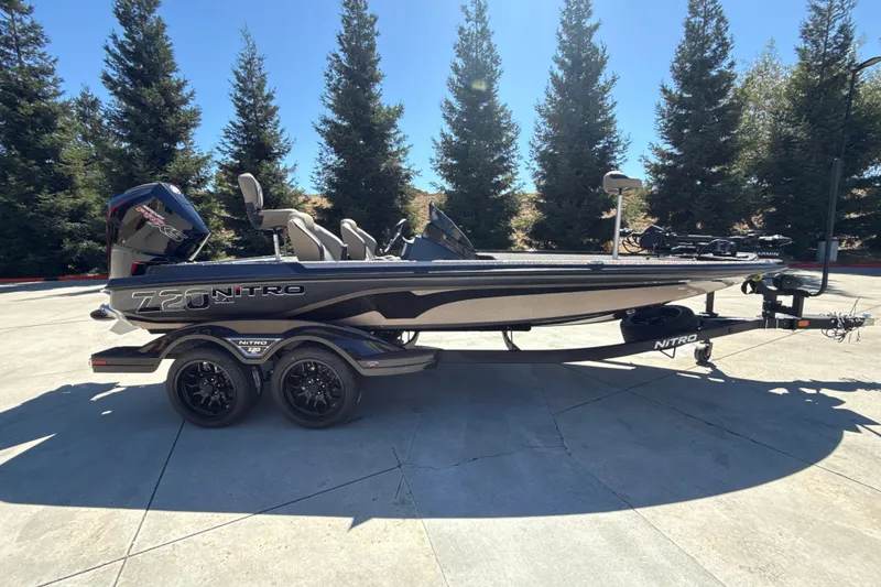 The Image of 2027 Nitro Z20 XL Pro boat on trailer, parked outdoors with trees in background. - 0