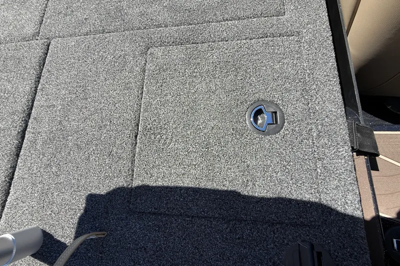 Slide: The Image of Carpeted deck of 2027 Nitro Z20 XL Pro boat with storage compartment latch. - 34
