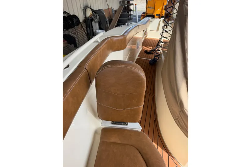 Slide: The Image of 2024 Scout 240 XSF boat interior with brown leather seating and teak flooring. - 15