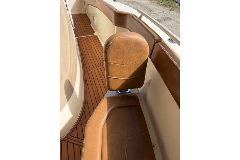 Slide: The Image of 2024 Scout 240 XSF boat interior with brown leather seating and wood-style flooring. - 16