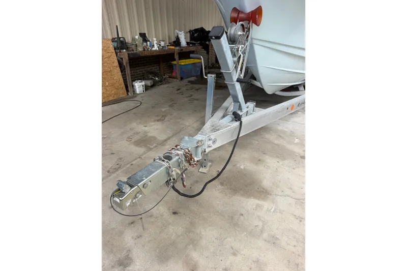 Slide: The Image of Trailer hitch of a 2024 Scout 240 XSF boat in a garage setting. - 50