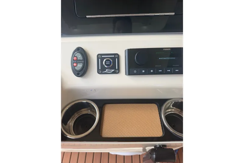 Slide: The Image of 2024 Scout 240 XSF boat console with controls, stereo system, and cup holders. - 23