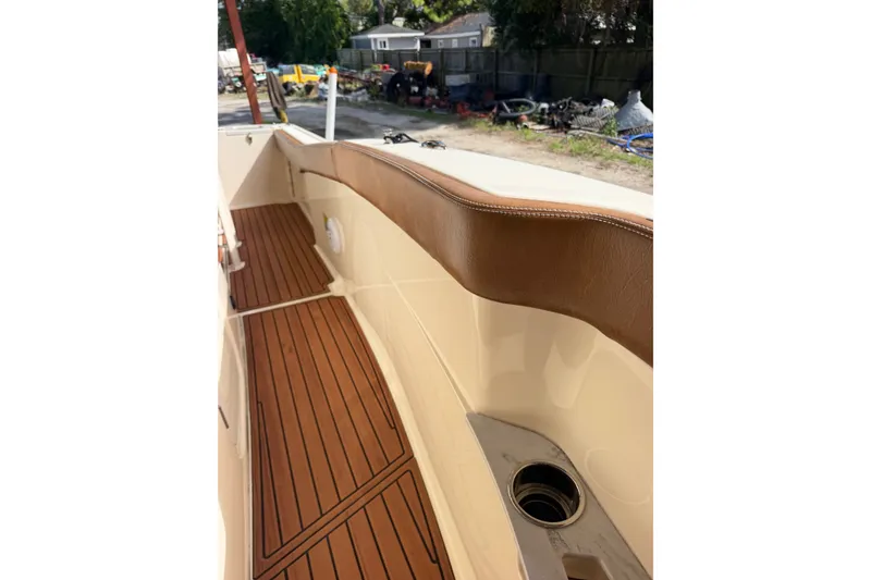 Slide: The Image of 2024 Scout 240 XSF boat interior with teak flooring and brown leather accents. - 17