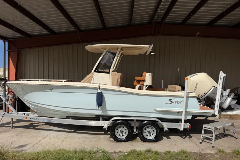Slide: The Image of 2024 Scout 240 XSF boat on trailer under shelter, side view. - 1