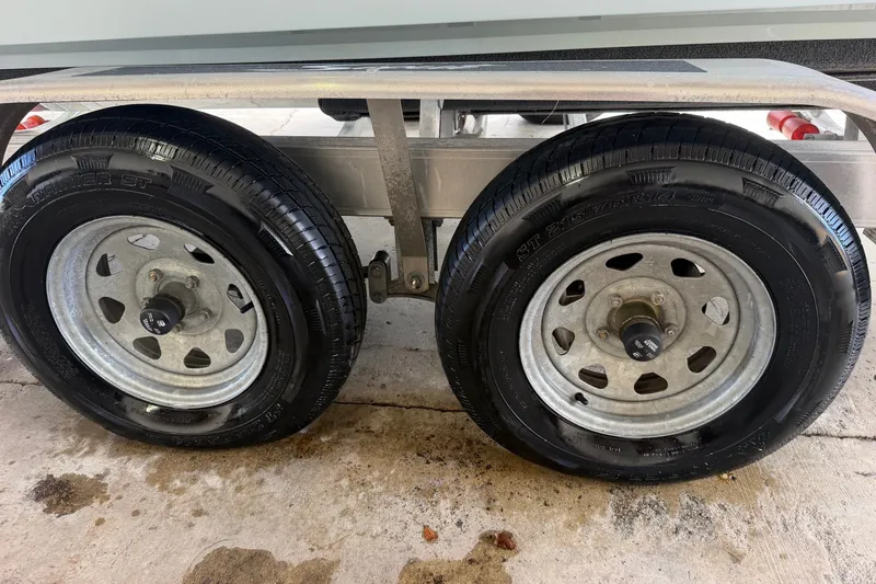 Slide: The Image of Dual wheels of a 2024 Scout 240 XSF trailer on a concrete surface. - 54
