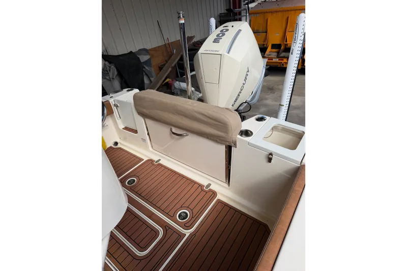 Slide: The Image of 2024 Scout 240 XSF boat interior with Mercury engine, featuring teak flooring and storage compartments. - 26
