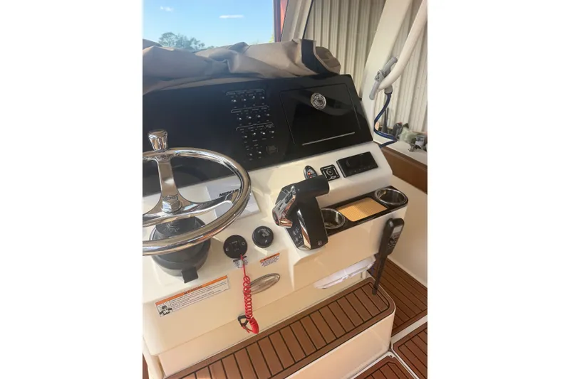 Slide: The Image of 2024 Scout 240 XSF boat dashboard with steering wheel and control panel. - 21