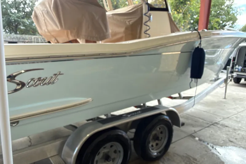 Slide: The Image of 2024 Scout 240 XSF boat on trailer, parked under a shelter. - 49