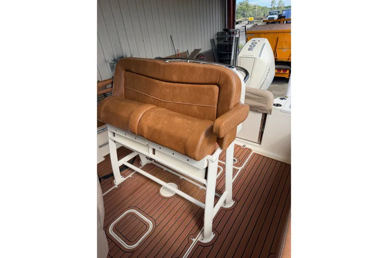 Slide: The Image of 2024 Scout 240 XSF boat interior with brown leather seating and wooden flooring. - 11