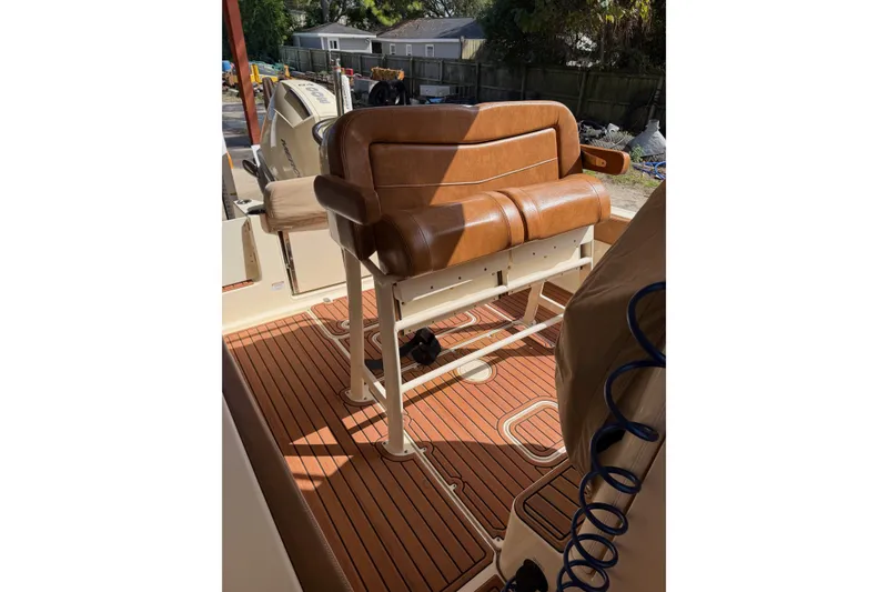 Slide: The Image of 2024 Scout 240 XSF boat interior with brown leather seating and teak flooring. - 12