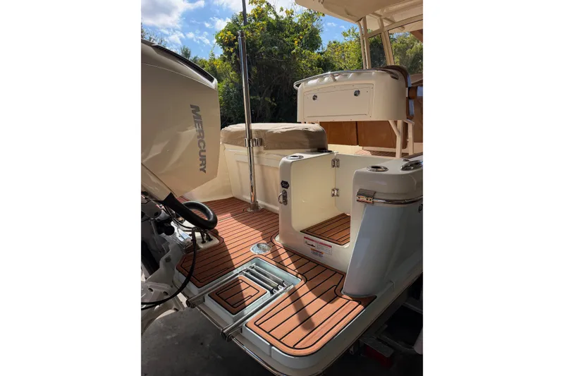 Slide: The Image of 2024 Scout 240 XSF boat interior with Mercury engine, featuring teak flooring and seating area. - 39