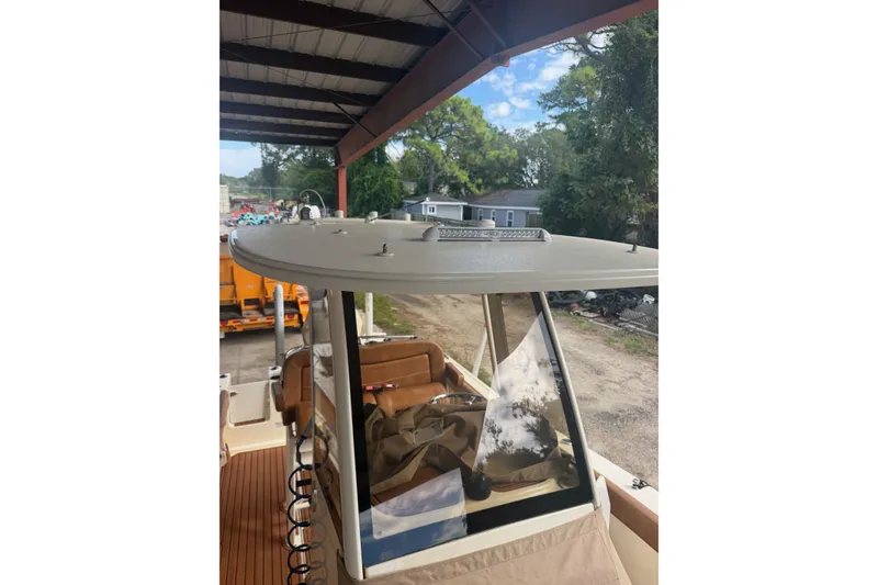 Slide: The Image of 2024 Scout 240 XSF boat under a metal canopy, showcasing its sleek design and interior. - 31