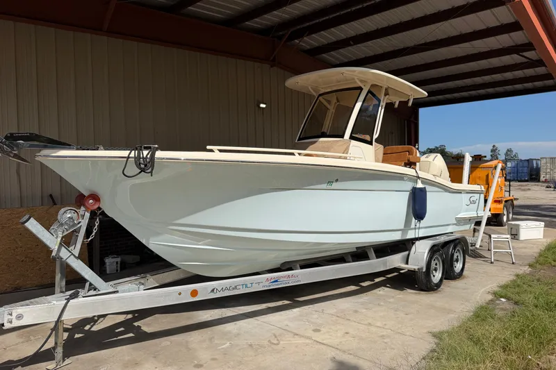 Slide: The Image of 2024 Scout 240 XSF boat on trailer in covered storage area. - 3