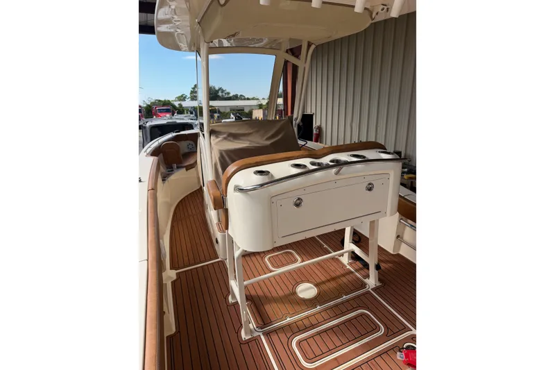 Slide: The Image of 2024 Scout 240 XSF boat interior with teak flooring and covered seating area. - 8
