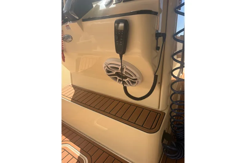 Slide: The Image of 2024 Scout 240 XSF boat interior with speaker and radio, featuring teak flooring. - 22