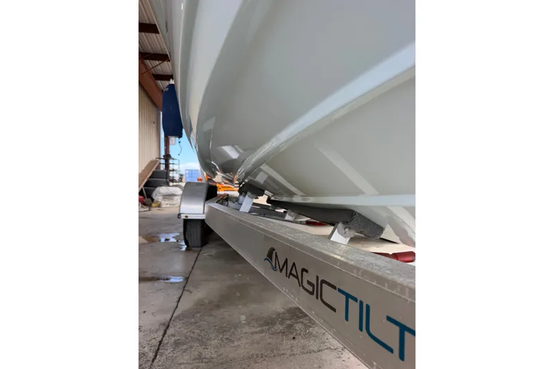 Slide: The Image of 2024 Scout 240 XSF boat on Magic Tilt trailer in a garage setting. - 52