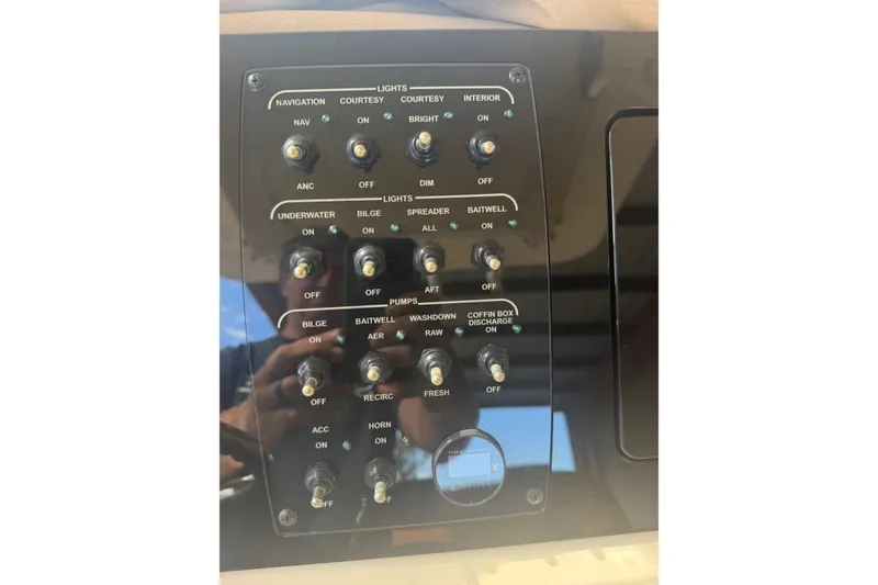 Slide: The Image of Control panel of a 2024 Scout 240 XSF boat with various switches and indicators. - 24